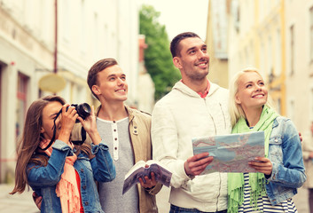 group of friends with city guide, map and camera