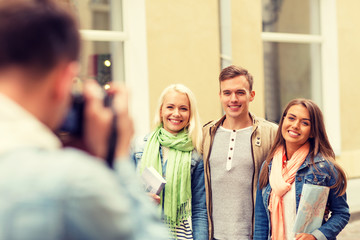 group of smiling friends taking photo outdoors