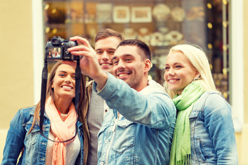 group of smiling friends making selfie outdoors