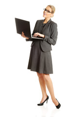 Businesswoman standing and holding a laptop