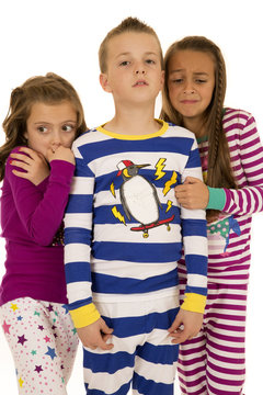 Three kids wearing winter pajamas two girls afraid
