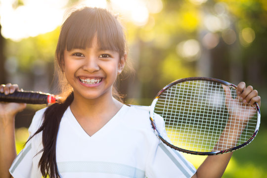 Little asian girl holding a badminton racket
