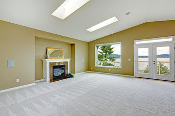 Empty spacious living room with walkout deck and fireplace.