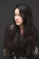 Young Asian woman on dark background.