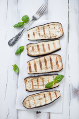 Grilled eggplant with green basil, view from above, studio shot