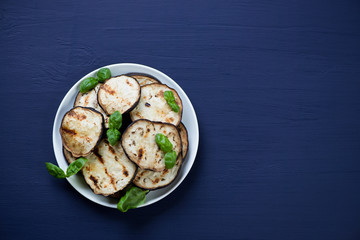 Grilled aubergine over dark blue wooden background, copyspace