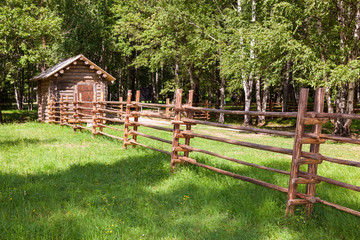 Wooden fence with small wooden house in countryside