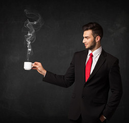 Businessman holding a white steamy cup
