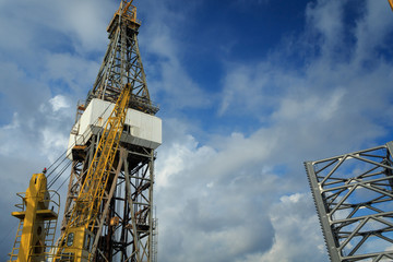 Fototapeta na wymiar Offshore Drilling Rig with Working Cranes on Cloudy Day