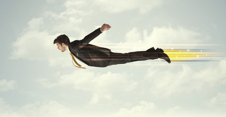Happy business man flying fast on the sky between clouds