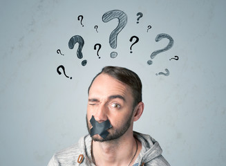 Young man with glued mouth and question mark symbols