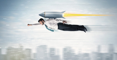 Superhero business man flying with jet pack rocket above the cit - obrazy, fototapety, plakaty