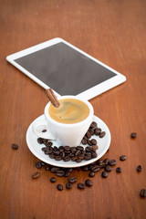 coffee with tablets on a wooden table in coffee shop