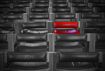 Single red chair in amongst monochrome chairs