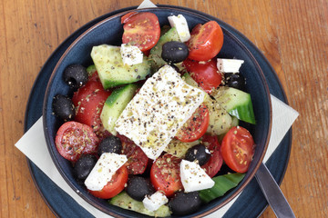 Greek salad in a deep blue bowl.