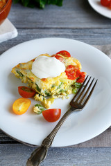 Casserole with cheese and vegetables on white plate