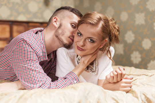 Young couple lying on the bed at hotel room