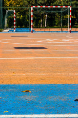 Blue and orange cement soccer yard in the park.