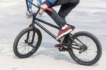 Young boy riding his BMX bike near ramps