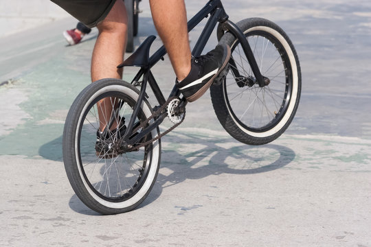 Young boy doing a trick with his BMX bike near ramps