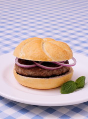 Hamburger on plate, white and blue checkered tablecloths