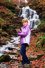 Little artist near waterfall