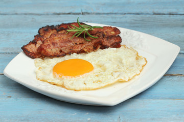 Breakfast - eggs and bacon on blue wooden table