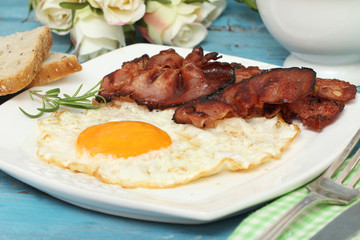 Breakfast - eggs and bacon on blue wooden table