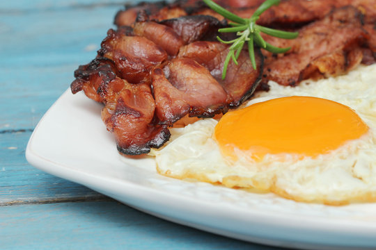 Breakfast - eggs and bacon on blue wooden table