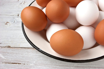 Chicken eggs in the white plate on the white table