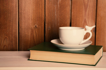 Old books and cup of coffee on table
