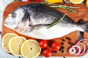Fresh raw fish and food ingredients on table