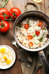 Tasty rice in pan on wooden table