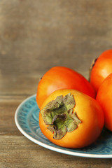 Ripe sweet persimmons, on wooden table