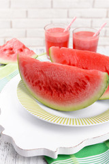 Juicy watermelon on table on brick wall background
