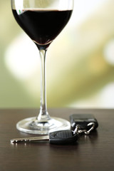 Glass of alcoholic drink and car key,