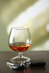 Glass of alcoholic drink and car key,