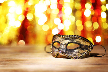 Beautiful carnival mask on table on bright background