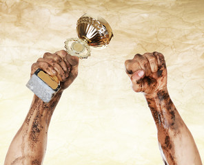 Gold cup in dirty hands