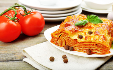 Portion of tasty lasagna on wooden table