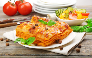 Portion of tasty lasagna on wooden table