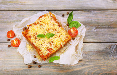 Portion of tasty lasagna on wooden table