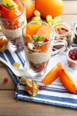Healthy layered dessert with muesli and fruits on table
