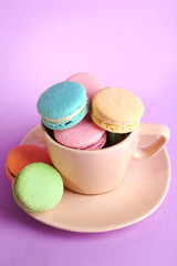 Assortment of gentle colorful macaroons in colorful mug