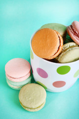 Assortment of gentle colorful macaroons in colorful mug