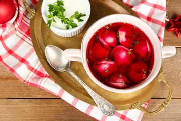 Traditional polish clear red borscht with dumplings in bowl