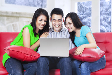 Group of asian people using laptop on sofa