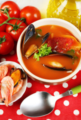 Tasty soup with shrimps, mussels, tomatoes and black olives in
