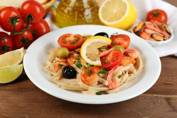Tasty pasta with shrimps, mussels, black olives and tomato