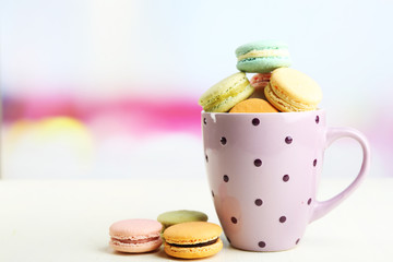 Assortment of gentle colorful macaroons in colorful mug